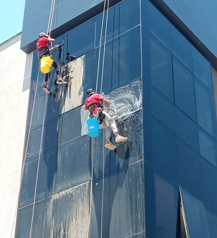 فريق تعليق بينظف واجهة برج زجاجية